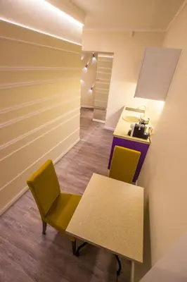 a room with a table and two chairs and a sink at Dysnos Avenue Apartments in Vilnius