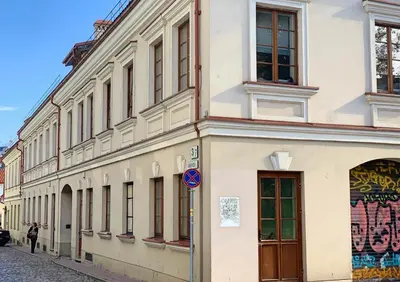 a building on a street with a person standing next to it at Dysnos Avenue Apartments in Vilnius