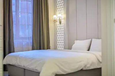 a bedroom with a white bed with a window at Dysnos Avenue Apartments in Vilnius