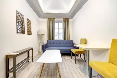 a living room with a blue couch and a table at Dysnos Avenue Apartments in Vilnius