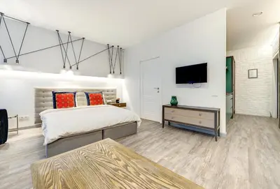 a bedroom with a bed and a tv on a wall at Dysnos Avenue Apartments in Vilnius
