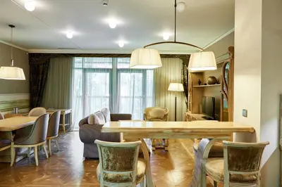a living room with a dining table and chairs at Grand SPA Lietuva Serviced Apartments Dzūkija in Druskininkai