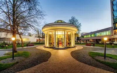 a large building with lights in front of a building at Grand SPA Lietuva Serviced Apartments Dzūkija in Druskininkai