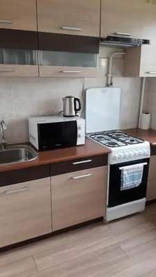 a kitchen with a stove and a microwave at Tulpių apartamentai in Panevėžys