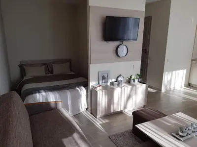 a hotel room with a bed and a clock on the wall at Apartamentai Vilniaus Street in Šiauliai