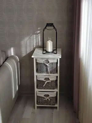 a white table with baskets and a candle on it at Apartamentai Centras in Šiauliai