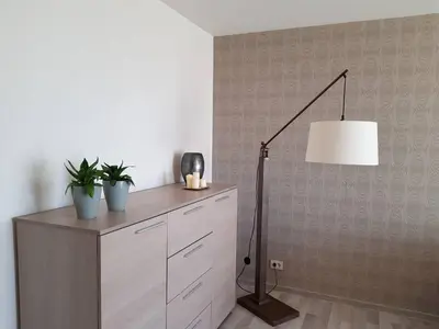a room with a desk with a lamp and plants at Apartamentai Centras in Šiauliai