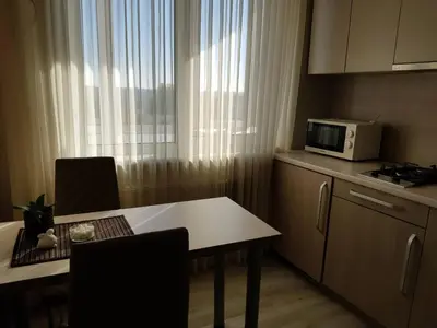 a small kitchen with a table and a microwave at Apartamentai Centras in Šiauliai