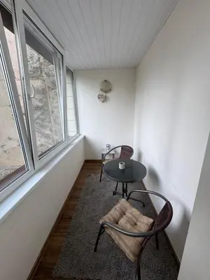 a room with two chairs and a table and a window at Apartamentai Dainų in Šiauliai