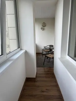 an empty hallway with a table and two windows at Apartamentai Dainų in Šiauliai