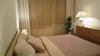 a bedroom with a bed and a lamp and a plant at Apartamentai Dainų in Šiauliai