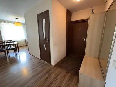 an empty living room with a door and a table at Apartamentai Dainų in Šiauliai
