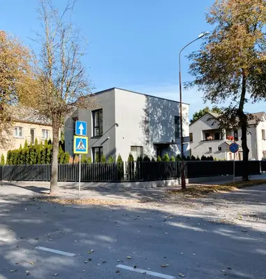a building with a sign on the side of a street at Apartamentai Vytauto Street in Šiauliai