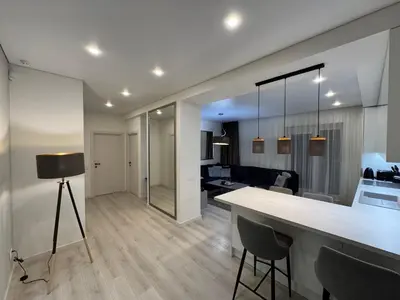 a kitchen and living room with a table and chairs at Apartamentai Vytauto Street in Šiauliai