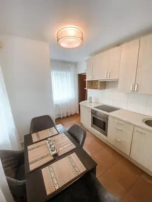 a kitchen with a table and chairs in a room at Apartamentai Vytauto Street in Šiauliai