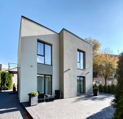 a white house with windows on a street at Apartamentai Vytauto Street in Šiauliai
