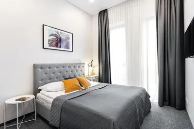 a bedroom with a bed and a large window at Kaunas Garden in Kaunas