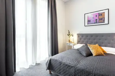 a bedroom with a bed and a large window at Kaunas Garden in Kaunas