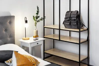 a black book shelf in a bedroom with a bag on it at Kaunas Garden in Kaunas