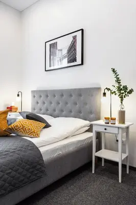 a bedroom with a bed and a nightstand with a table at Kaunas Garden in Kaunas