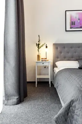 a bedroom with a bed and a table with a plant at Kaunas Garden in Kaunas