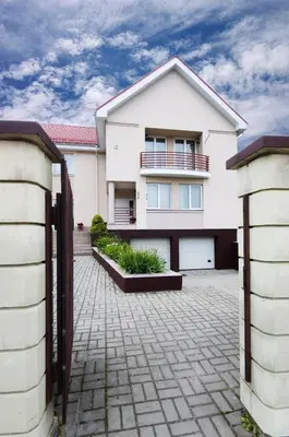a white house with a brick driveway at VGH accommodation services in Vilnius