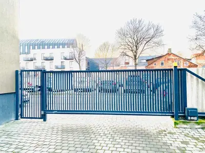a blue metal gate in front of a building at Cosy 1BD Apartment in Old Town by Domvia in Kaunas