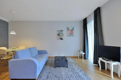 a living room with a blue couch and a tv at Cosy 1BD Apartment in Old Town by Domvia in Kaunas