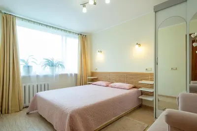 a bedroom with a bed and a large window at Du draugai 1 in Druskininkai