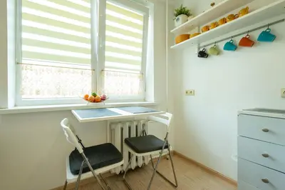 a kitchen with a desk and two chairs in front of a window at Du draugai 1 in Druskininkai
