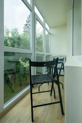 a black chair sitting in front of a window at Du draugai 1 in Druskininkai
