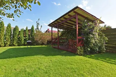 a gazebo in a yard with green grass at White Cottage in Druskininkai