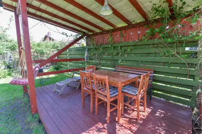 a wooden table and chairs on a wooden deck at White Cottage in Druskininkai