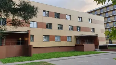 a building with windows and grass in front of it at Garden Studio by the Lake with Air-Con and Infrasauna in Druskininkai