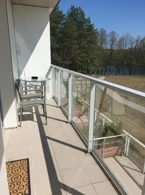a balcony with a bench and a view of a field at Garden Studio by the Lake with Air-Con and Infrasauna in Druskininkai