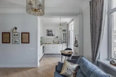 a living room with a blue couch and a kitchen at Avenue in Šiauliai