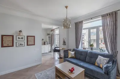 a living room with a blue couch and a table at Avenue in Šiauliai
