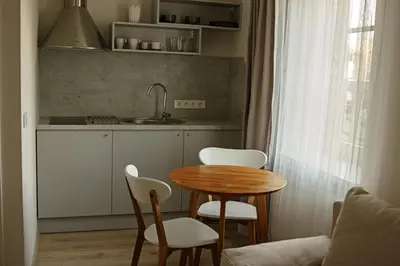 a kitchen with a table and chairs and a sink at Centro apartamentai in Birštonas