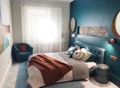 a bedroom with blue walls and a bed and a mirror at Luxury old town apartment in Vilnius