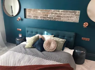 a bedroom with a bed with a blue wall at Luxury old town apartment in Vilnius