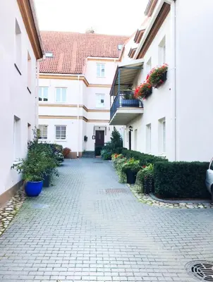 a brick walkway between two buildings with flowering plants at Luxury old town apartment in Vilnius