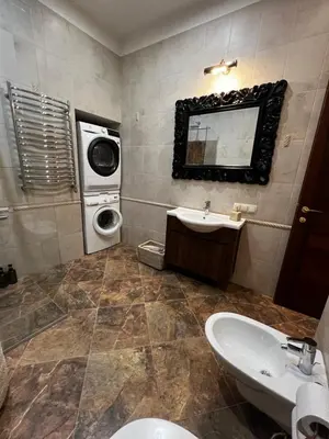 a bathroom with a sink and a washing machine at Luxury old town apartment in Vilnius