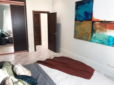 a bedroom with a bed and a painting on the wall at Luxury old town apartment in Vilnius