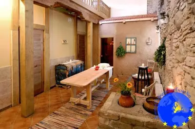 a living room with a table and a stone wall at Pakruojis Manor Hotel Miller's house in Pakruojis