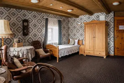 a bedroom with a bed and a table and chairs at Pakruojis Manor Hotel Miller's house in Pakruojis