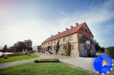 a large brick building with a red roof at Pakruojis Manor Hotel Miller's house in Pakruojis