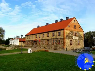 a large brick building with a red roof at Pakruojis Manor Hotel Miller's house in Pakruojis