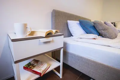 a bedroom with a bed and a night stand with a book at MOCHA HOUSE 3 ROOM CENTRAL APARTMENT 56d in Kaunas