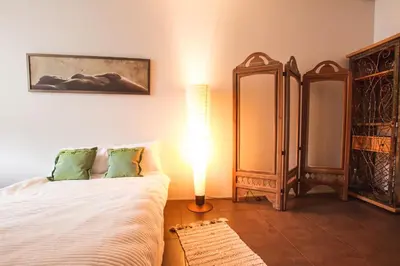 a bedroom with a bed and a lamp and a mirror at MOCHA HOUSE 3 ROOM CENTRAL APARTMENT 56d in Kaunas