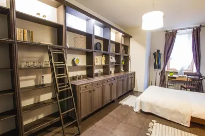 a bedroom with wooden shelves and a bed and a ladder at MOCHA HOUSE 3 ROOM CENTRAL APARTMENT 56d in Kaunas